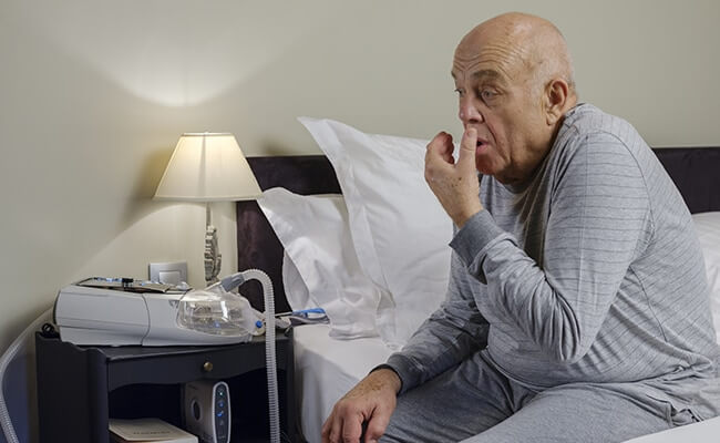 COPD-man-sitting-coughing-non-invasive-ventilation-MOBILE