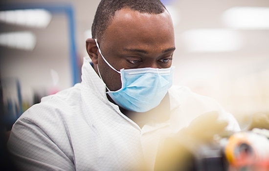 Mand med maske arbejder på et laboratorium